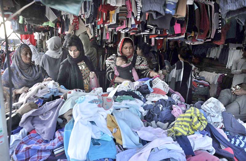 People selecting warm clothes from a venders stall at weekly Bazaar as demand increased during winter season