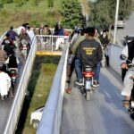 A large number of Motorcyclists crossing the bridge at Srinagar Highway in the Federal Capital