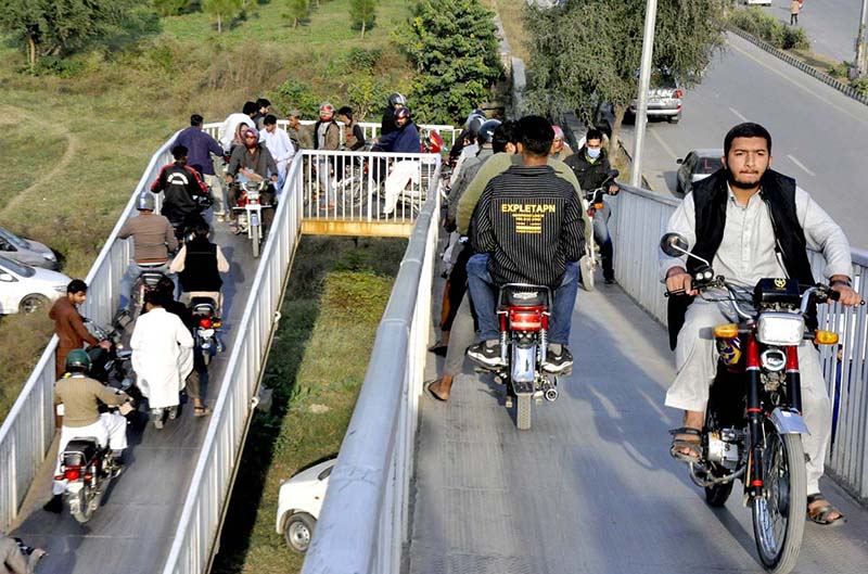 A large number of Motorcyclists crossing the bridge at Srinagar Highway in the Federal Capital