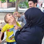 A lady health worker administering polio drops to a child during anti-polio vaccination campaign in the city.