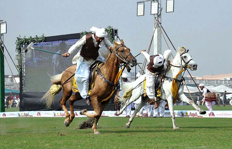 Horse riders aiming at their target on the last day of the Tent Pegging Championship 2023 "Lahore Lahore Aey" festival organized by the Parks and Horticulture Authority at Fortress Stadium