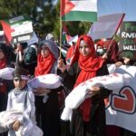 Students showing solidarity with the children of Palestine during march at Charing Cross Chowk, Main Peshawar Road.