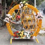 A vendor decorating his work place with flower garland used for a wedding and mehndi ceremony