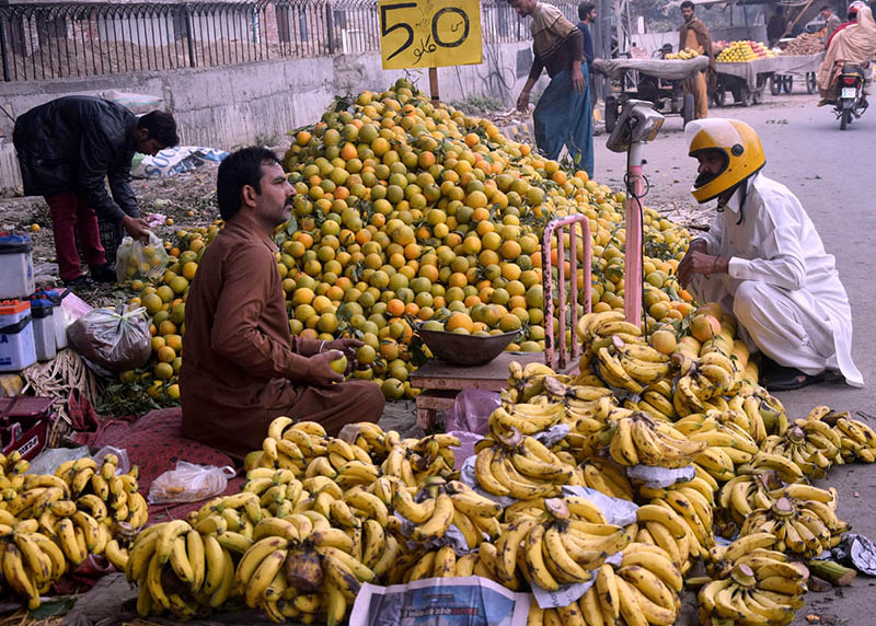 A vendor selling fruits at his roadside setup