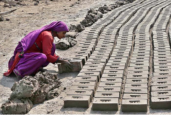 A woman labourer busy in preparing bricks at Tando Hyder.