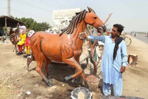 A vendor displaying statue of a horse to attract the customers at Eidgah road.