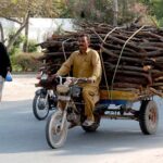 Timber-laden motorcycle cart on its way in preparation of winter season