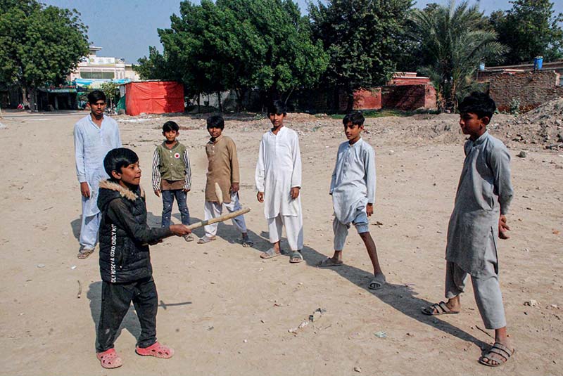 Children are playing Guli Danda in a local ground
