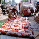 A worker stitching quilts as per demand of the customers in preparation of winter season