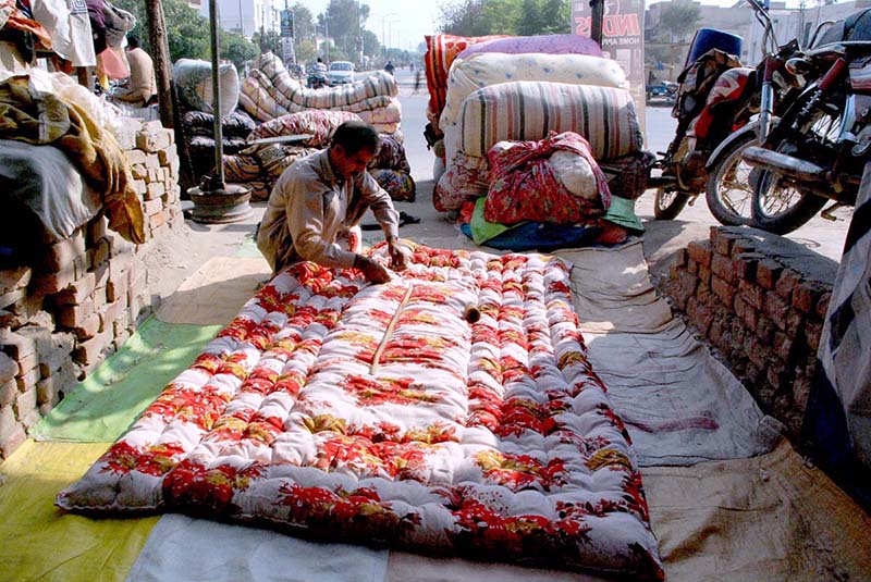 A worker stitching quilts as per demand of the customers in preparation of winter season