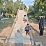 Children joyfully sliding down the slide at Sitara Market