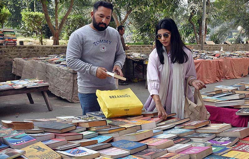 People are purchasing old books from the roadside vendor.