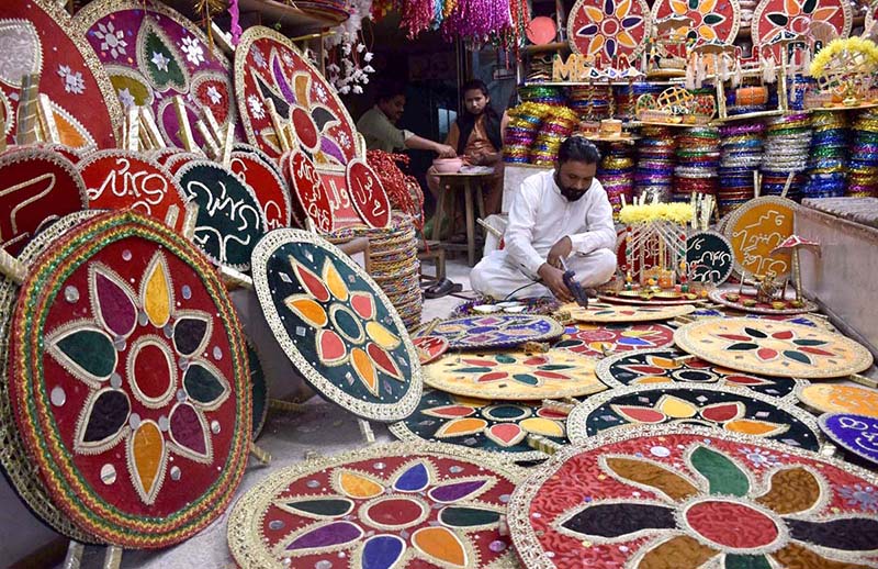 A vendor preparing the different kind of decorative stuff use for marriage ceremonies at his workplace