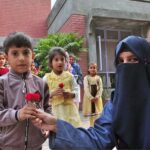 Students are presenting flowers to SOS Village children during an event organized by NCHD on the eve of World Children's Day at SOS Village