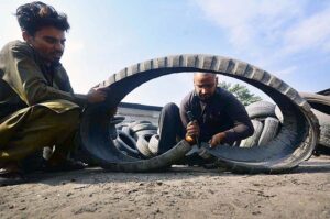 Laborers busy in cutting scrap tires at scrap tire godown