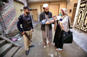 Polio worker administering polio drops to a child during anti-polio vaccination campaign in the Provincial Capital. 