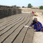 A woman labourer busy in preparing bricks at Tando Hyder.