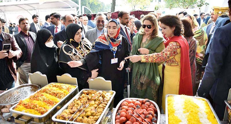First Lady Begum Samina Alvi visiting stalls featuring traditional cuisines, arts and crafts of different countries at Pakistan Foreign Office Women's Association's Annual Charity Bazar