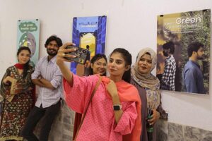 Visitor capturing the moments through cell phone during “Jashan-e-Maholiat” Art paintings for Environment Exhibition organized by Sindh Community Foundation (SCF) at Mehran Arts Council
