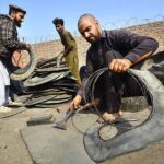 Laborers busy in cutting scrap tires at scrap tire godown