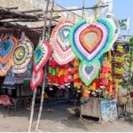 A vendor displaying the flowers and money garlands for wedding and other functions to attract the customers at his roadside setup