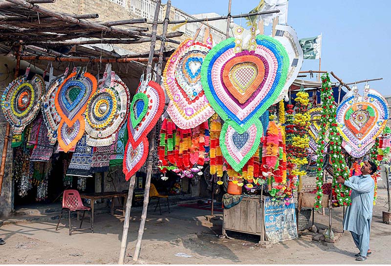 A vendor displaying the flowers and money garlands for wedding and other functions to attract the customers at his roadside setup