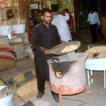 A labourer busy in roasting peanuts at his workplace as demand increased during winter season