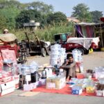 A vendor displays plastic containers to attract customers at his roadside setup