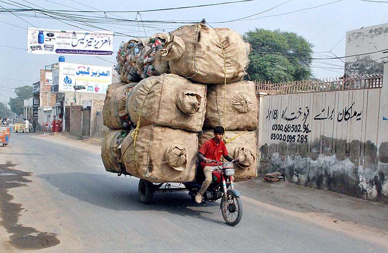 A young boy is loaded bags full of empty plastic bottles on a motorcycle which can cause any accident