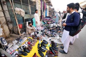 Vendor selling and displaying second hand shoes to attract the customers at Hashtnagri area