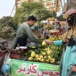 A woman buying guavas from a roadside vendor