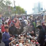 Women purchasing used footwear and warm clothes from roadside vendors in Saddar area, due to inflation it is difficult to buy new things