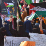 Women holding posters and banners as they attend the solidarity conference for the people of Palestine organized by Pakistan Markazi Muslim League at Shahra e Quaid