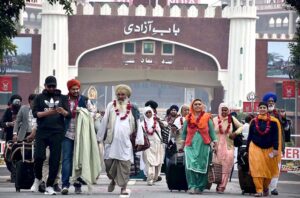 A large number of Sikh Yatrees stands in queue at Waghah Border for immigration procedure after arriving in Pakistan to participate in religious rituals on the occasion of 554th Birth Anniversary of Guru Nanak at Nankana Sahib