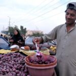 A vendor selling fruits at his roadside setup.