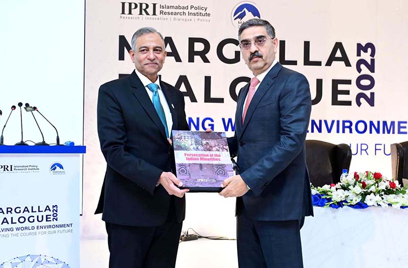 President of IPRI Dr. Raza Muhammad presents the book "Persecution of the Indian Minorities" to caretaker Prime Minister Anwaar-ul-Haq Kakar