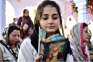 A Sikh woman yatree performing her religious rituals on the occasion of 554th birth anniversary of Guru Nanak Dev in Nankana Sahib, Guru Nanak was the founder of the religion of Sikhism and the first of ten Sikh Gurus. His birth is celebrated worldwide as Guru Nanak Gurpurab on Kartik Pooranmashi, the full-moon day in the month of Katak, October–November