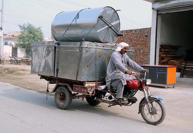 Daily wager loaded with Trunks on his motorcycle-cart on way to destination