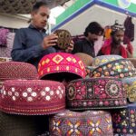 People purchasing Sindhi caps in connection with upcoming Sindhi Ajrak Topi Culture Day at Royal Road.