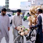 A man is purchasing handmade sparrow grass nests from roadside stall