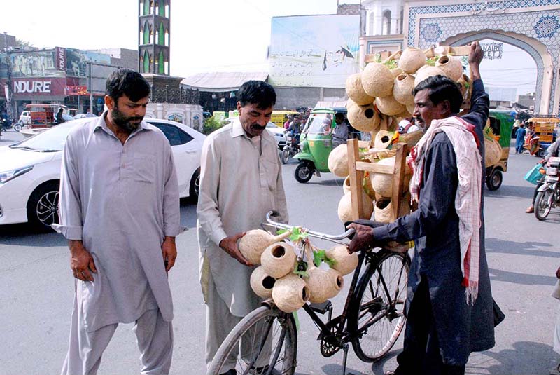 A man is purchasing handmade sparrow grass nests from roadside stall
