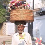 An elderly man is selling handmade paper flowers to earn livelihood for children at Shah Jamal