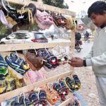 A vendor selling and displaying shoes at G-7