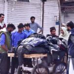 People buying warm clothes and jackets from roadside vendor as the Mercury falls rapidly