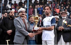Secretary Forest Gilgit-Baltistan Zafar Waqar Taj giving away trophy to the player of the match during the final match of the Jashan-e-Azadi free polo tournament at Aga Khan Shahi polo ground