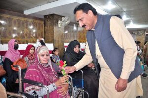 Deputy Director NCHD Mehar Umar Daraz Ghauri giving a flower to a Special woman during an event on world Disability Day organized by DC welfare in a local hotel
