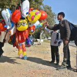 School children keenly viewing different shapes balloons displayed by vendor at G-7 in Federal Capital