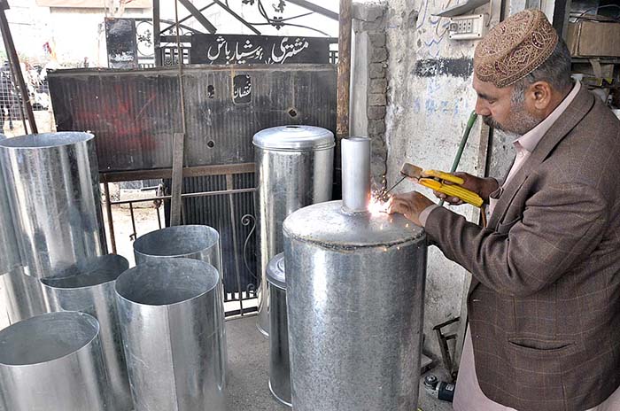 A worker busy in making geyser at his shop as its demand increased during winter season.