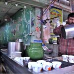 A vendor preparing tea for his customers in a local hotel