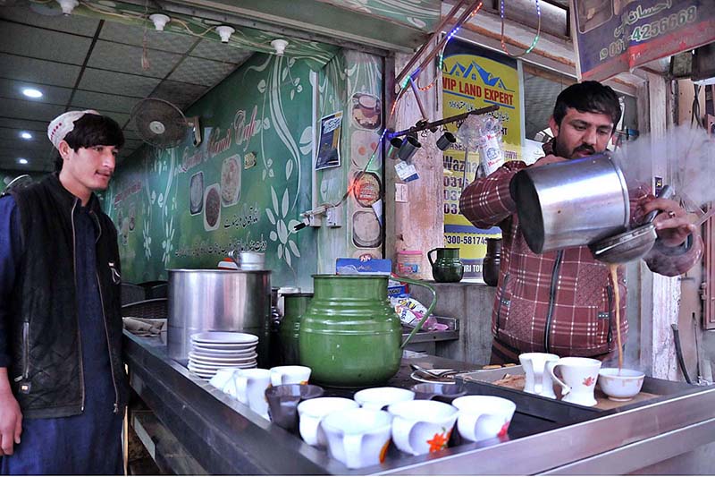 A vendor preparing tea for his customers in a local hotel